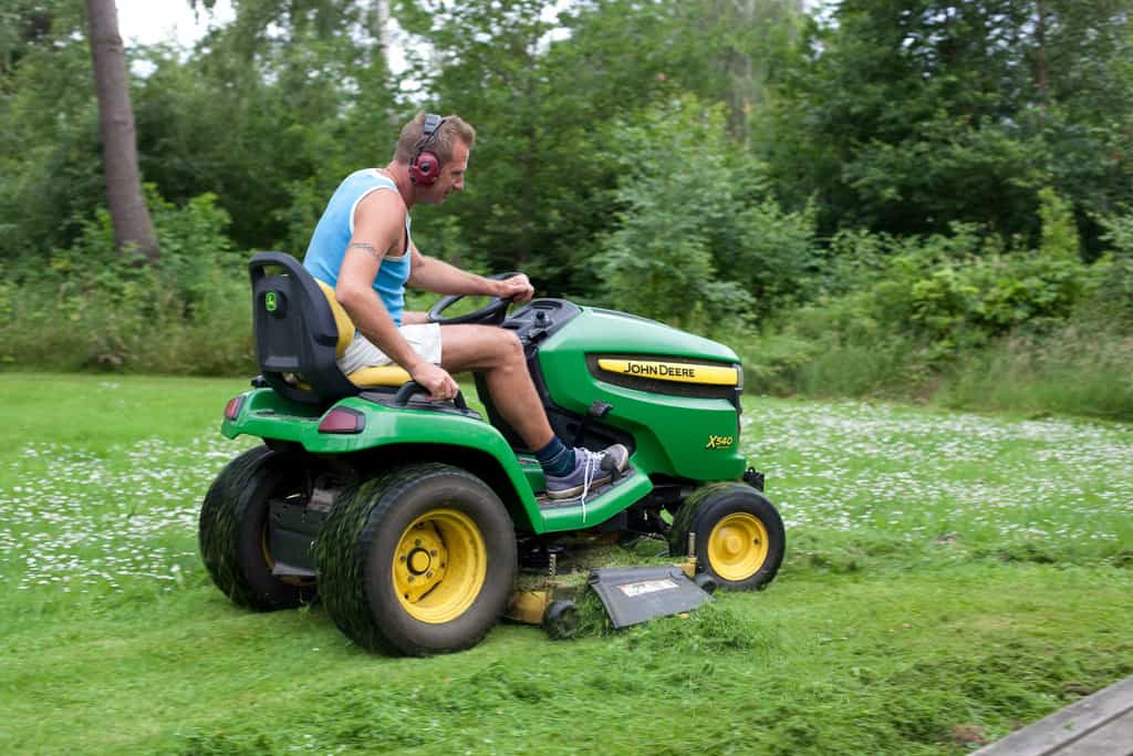 guy on a john deere riding lawn mower